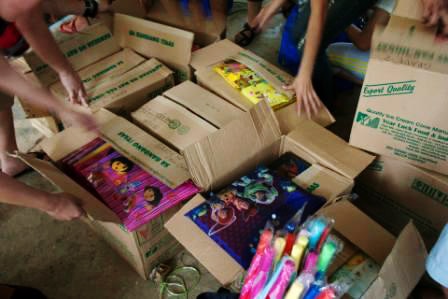 photo: donated school supplies packed in cardboard boxes
