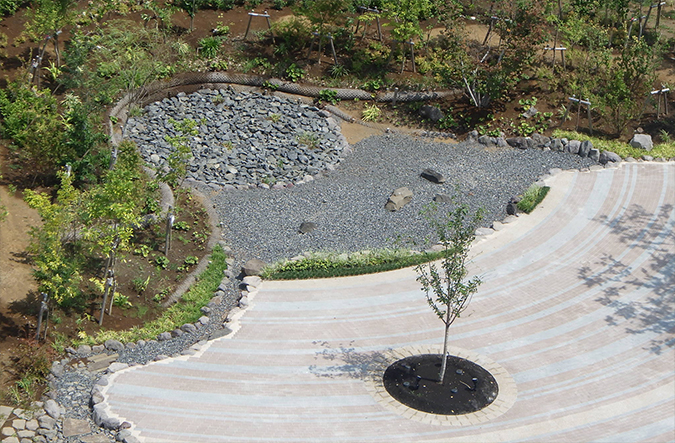 photo: Eight symbolic trees representing planets are arranged around a pond representing the sun.