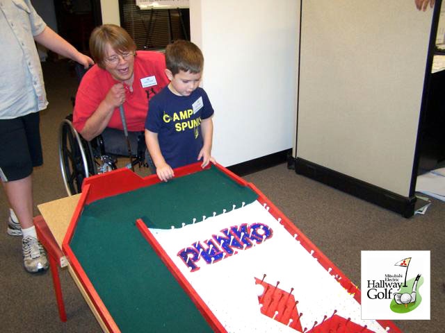 photo: A student from a local special education class and his teacher participate in Hallway Golf