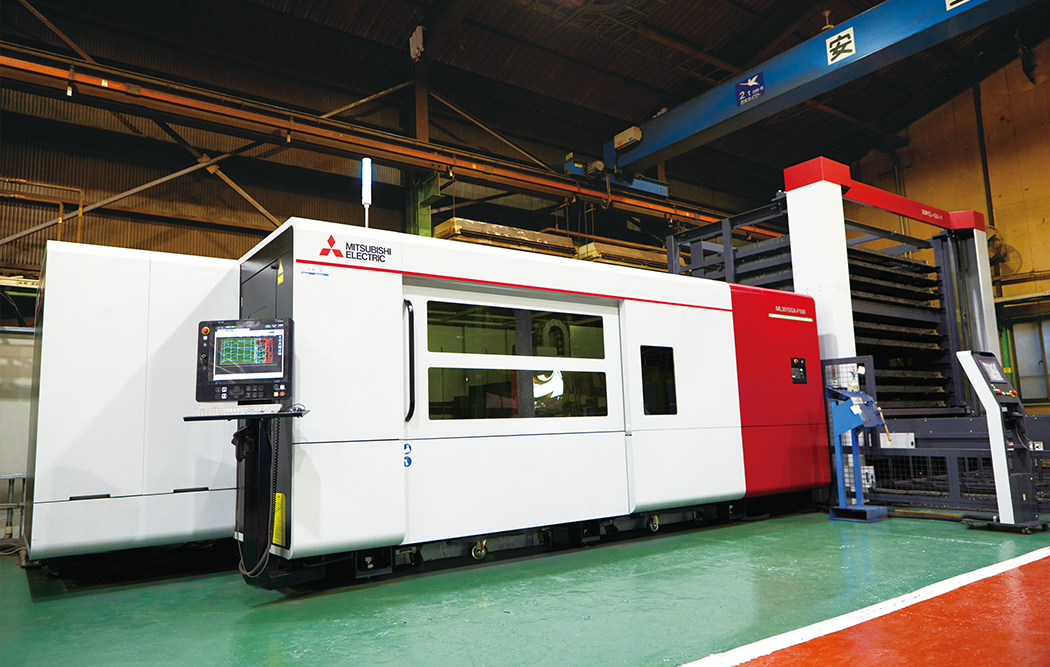 The Mitsubishi Electric ML3015GX-F100 fiber laser processing machine installed at the Kawaguchi Plant is an example of the world’s first laser processing machines to be equipped with artificial intelligence (AI)*. The AI system evaluates the cutting process using sound as well as light data and supports automatic nozzle replacement.