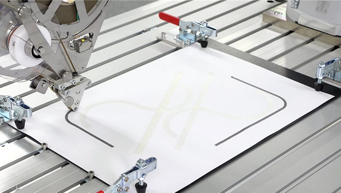 Automated double-sided tape application system using MELFA ASSISTA (Left). The adhesive on the Mobile Tape has been applied in a striped wave-pattern, allowing the tape to be laid down in curved shapes (Right)