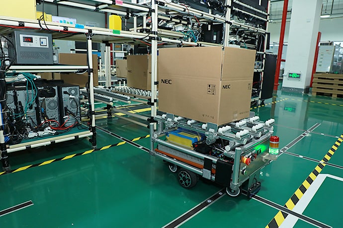The AGV was developed in-house using a Mitsubishi Electric PLC. Routes can be changed by GOT touchscreen operation.