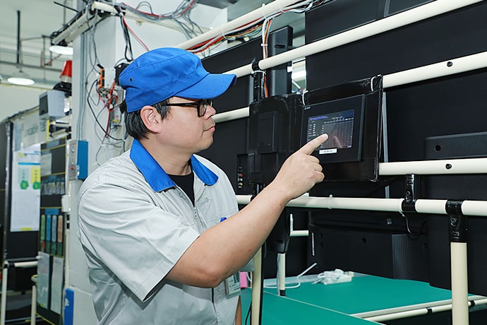 The AGV was developed in-house using a Mitsubishi Electric PLC. Routes can be changed by GOT touchscreen operation.